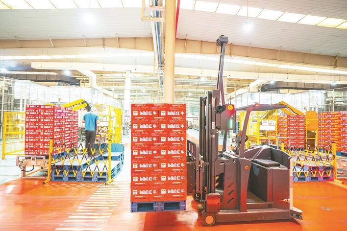 红牛维他命饮料（湖北）有限公司第三车间，无人叉车自主行驶运送刚下线的饮料。