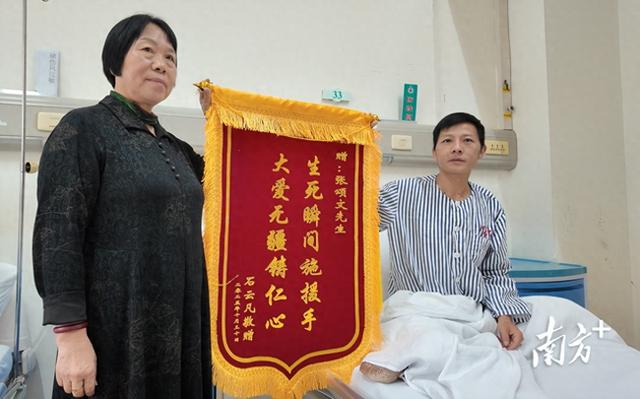 11月11日，粤北人民医院口腔科病房里，石先生展示为张颂文准备的锦旗。图源：南方+客户端