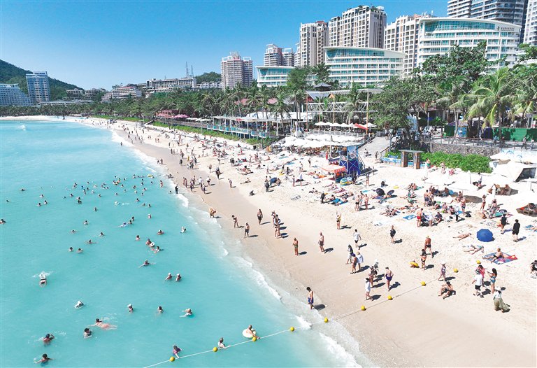 近日，来自国内外的游客在三亚大东海旅游区沙滩晒太阳，感受热带海滨风光的温暖。海南日报全媒体记者 王程龙 摄
