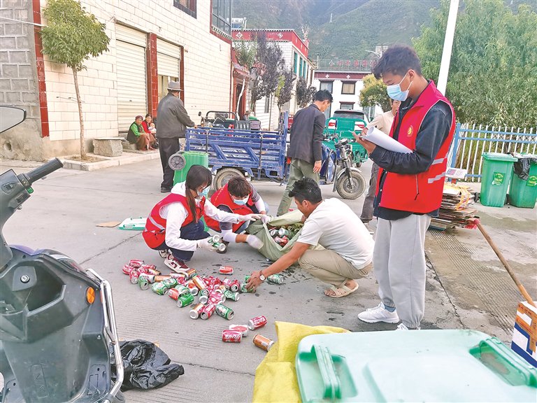 图为塘麦村党员帮助村民分拣易拉罐并登记台账。记者 武沛涛 丹增平措 摄