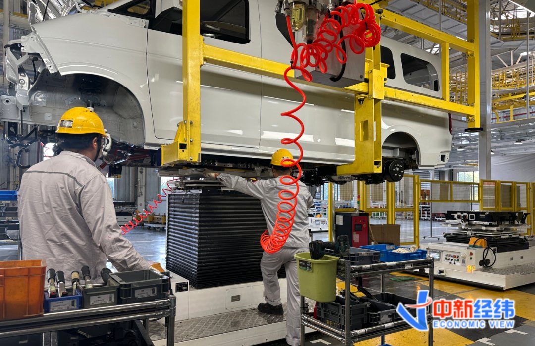 AGV机器人辅助一线工人为车辆装上动力电池 中新经纬 龚宸芫摄