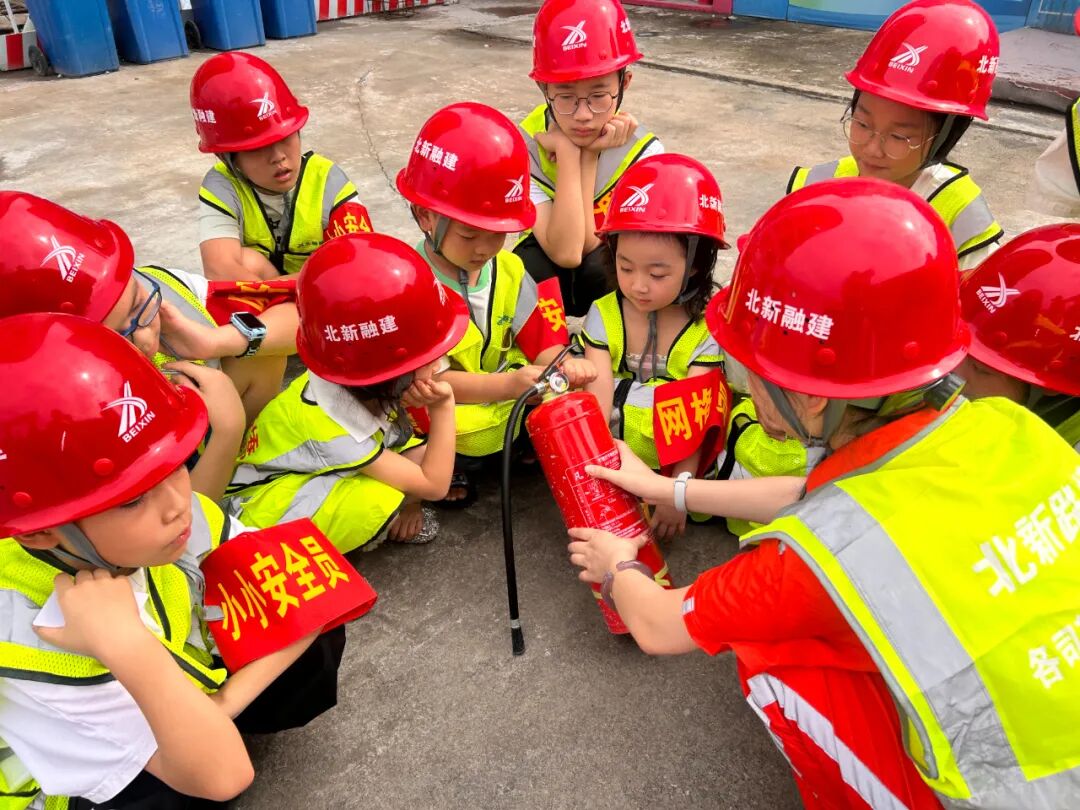 北新融建公司“小小安全员”们正在学习灭火器的正确使用方法