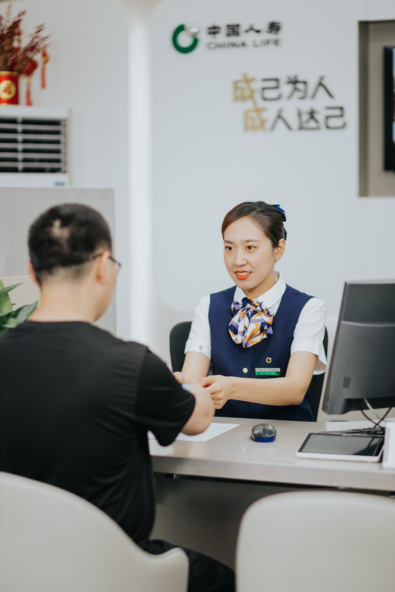 图：柜面服务人员为客户办理业务。