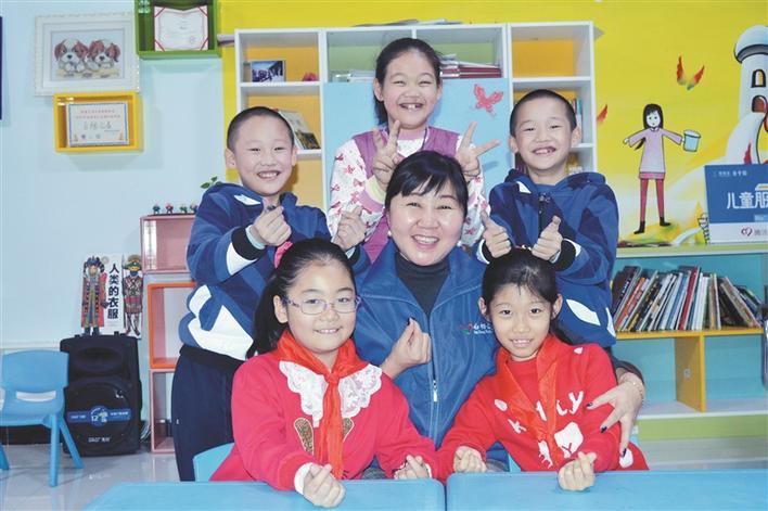 马学敏（前中）和孩子们合影（资料图片）。李沛 摄