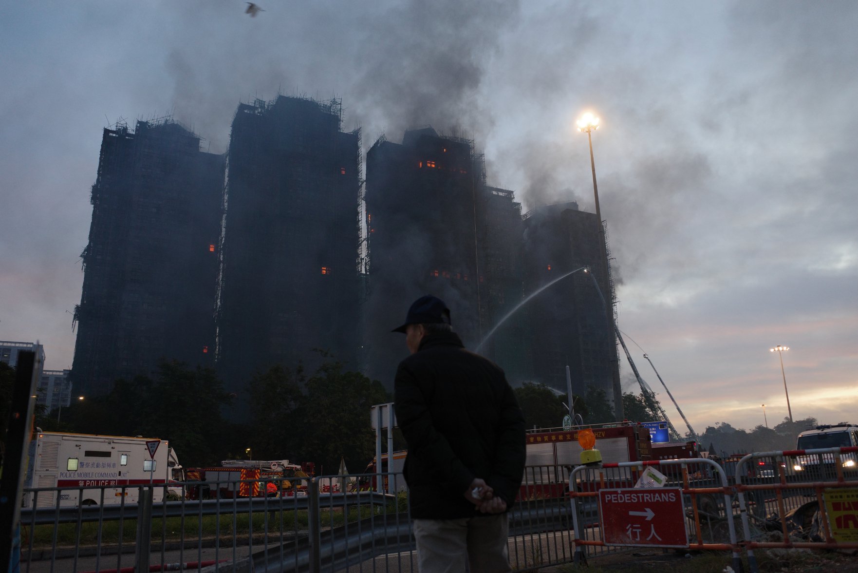 27日上午，一位受灾居民正远远看着自己的房子。（图源：时代周报记者 傅一波/摄）