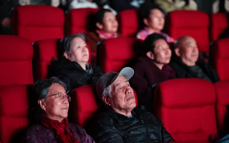 12月1日，黄新民和老伴儿坐在影院内，观看无障碍影片《热烈》。 新京报记者 王飞 摄