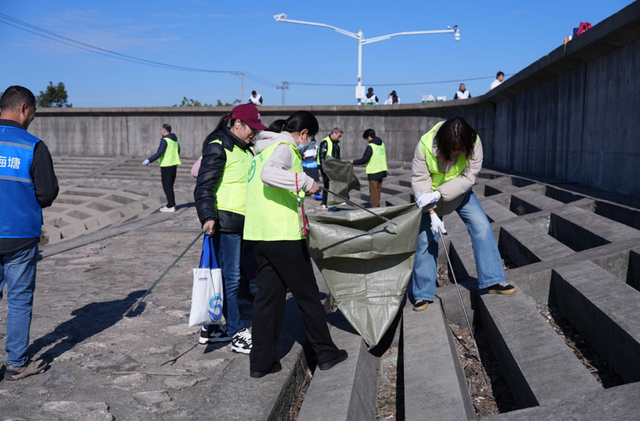 志愿者在奉贤沿海区域捡拾垃圾。 来源：上海市生态环境局