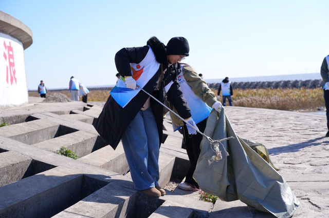 志愿者在奉贤沿海区域捡拾垃圾。 来源：上海市生态环境局