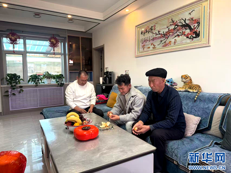 圖為張光龍在金山鎮生態及地質災害避險搬遷安置點內的新房和家人圍坐。新華網（劉欣瑜 攝）