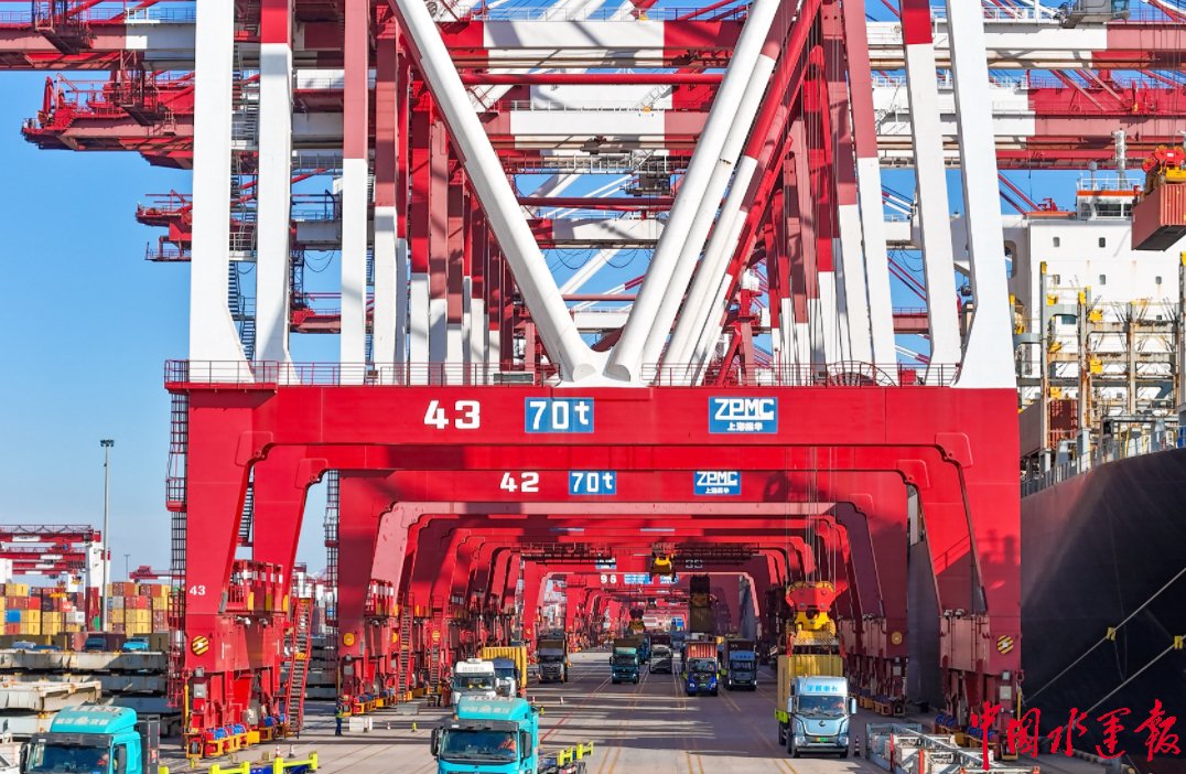 12月8日，在山东港口青岛港，集装箱卡车在运送货物。