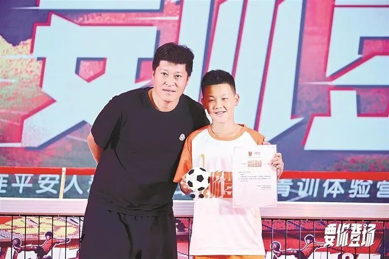 市足协副主席、青训中心青训总监张耀坤向首位报名参与公益足球青训体验营活动的同学赠送礼物。莱超 摄