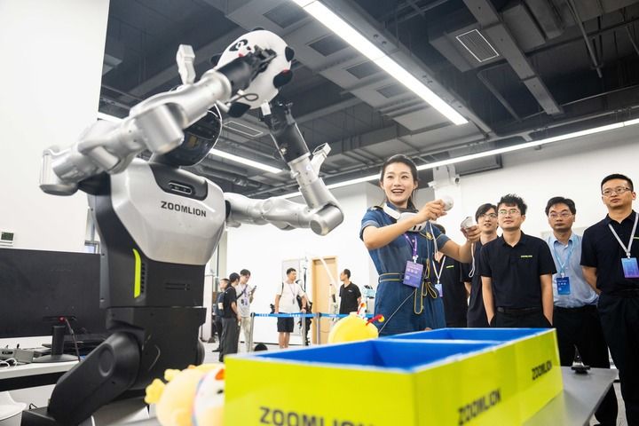 2025年9月15日，观众在湖南湘江新区长沙智谷操作人形机器人进行娃娃抓取。新华社记者 陈思汗 摄