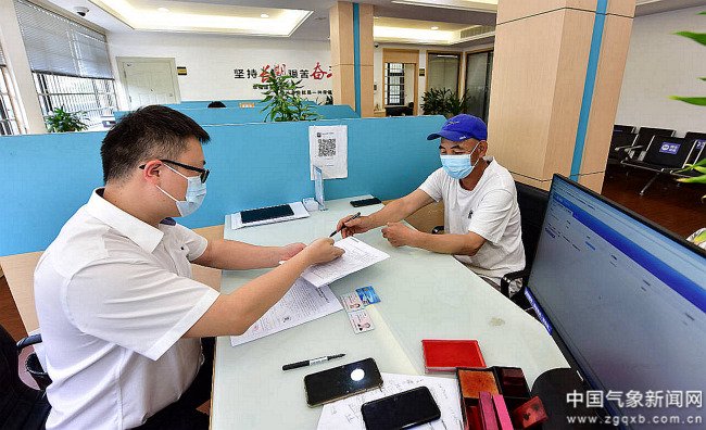 2022年，张仕明（右）申请“气候 贷”签字现场 图/王鹏洲