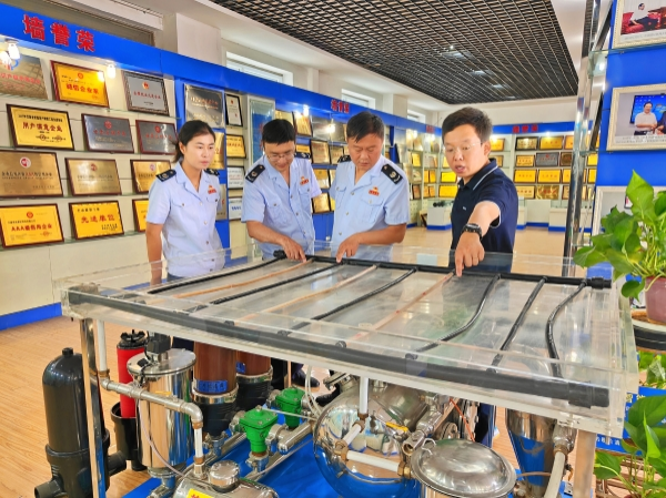 图为大禹节水集团股份有限公司财务副总监寇潇雨为税务干部讲解节水灌溉过滤设备运作原理