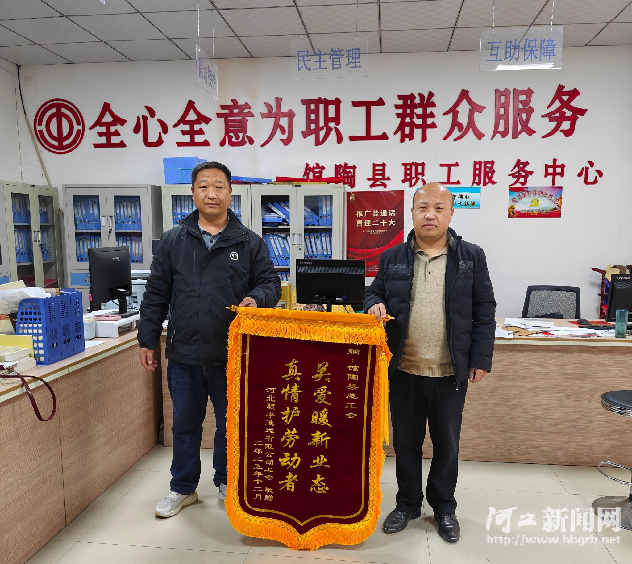 河北顺丰快递有限公司工会工作人员（左）为馆陶县总工会赠送锦旗