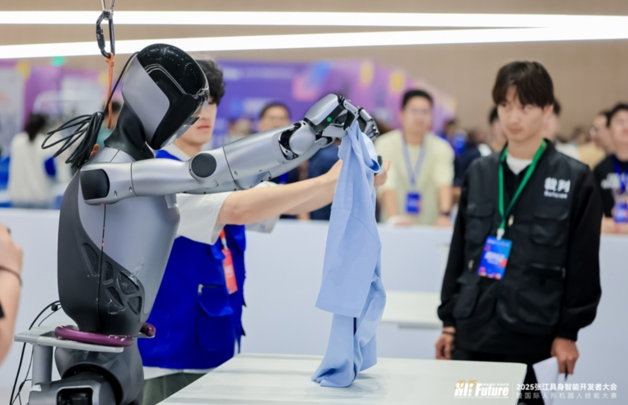 今年5月,2025张江具身智能开发者大会暨国际人形机器人技能大赛上,机器人参加叠衣比赛。(供图)