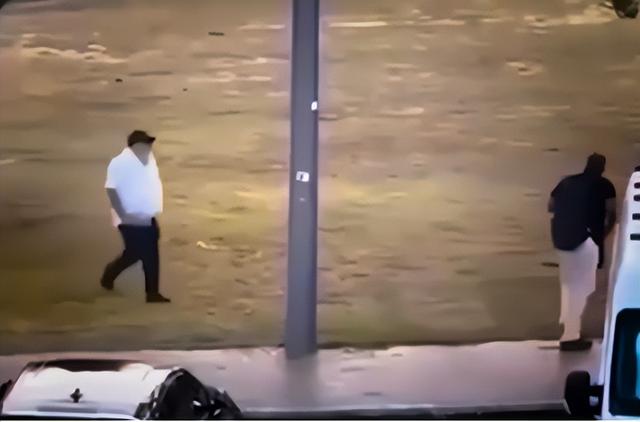 监控画面显示：一名男子手拿砖块走向持枪凶手。图源：澳媒