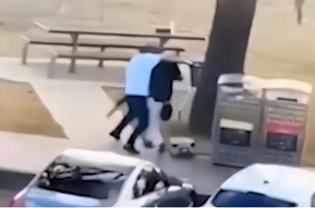 监控画面显示：一名路人男子走向持枪凶手夺枪时与其扭打在一起。图源：澳媒