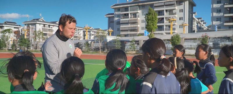 沃尔夫斯堡足球俱乐部的足球教练正在向四川布拖依撒小学的女足球员们讲授技战术。