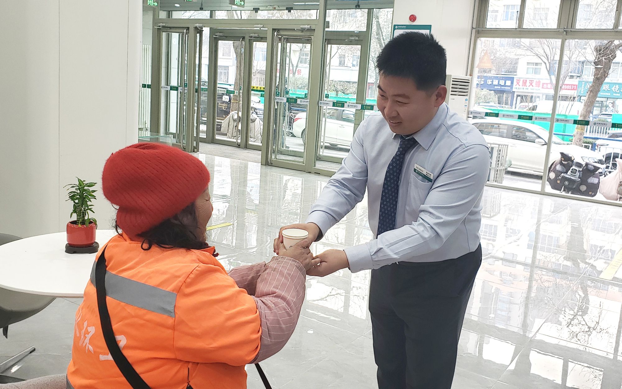 农行城中支行工作人员为环卫工人送上热水，用实际行动传递社会的温暖与关怀。          