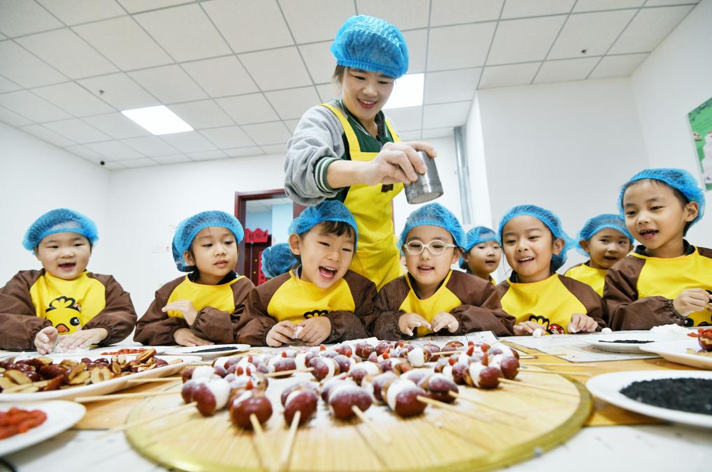   12月19日，在山东省乐陵市天和嘉园幼儿园，小朋友在老师的指导下做小枣面食。新华社发（刘振兴 摄）