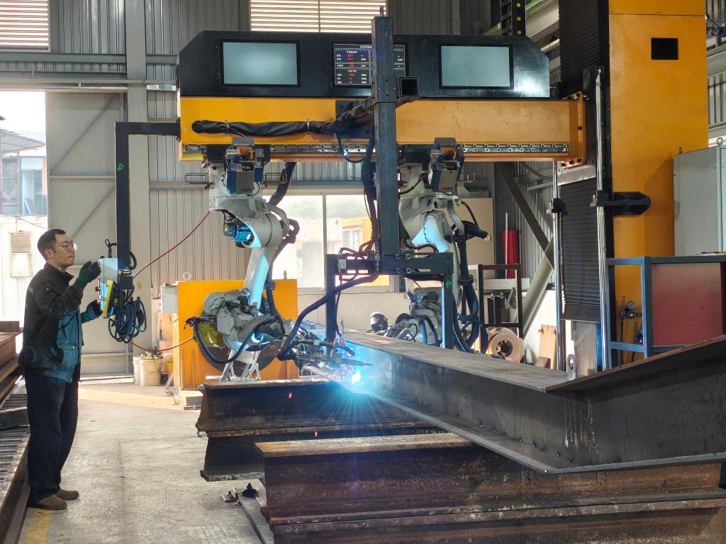 12月4日，香港和利绿色动力有限公司员工梁志豪使用智能焊接系统焊接钢材。新华社记者 刘英伦 摄