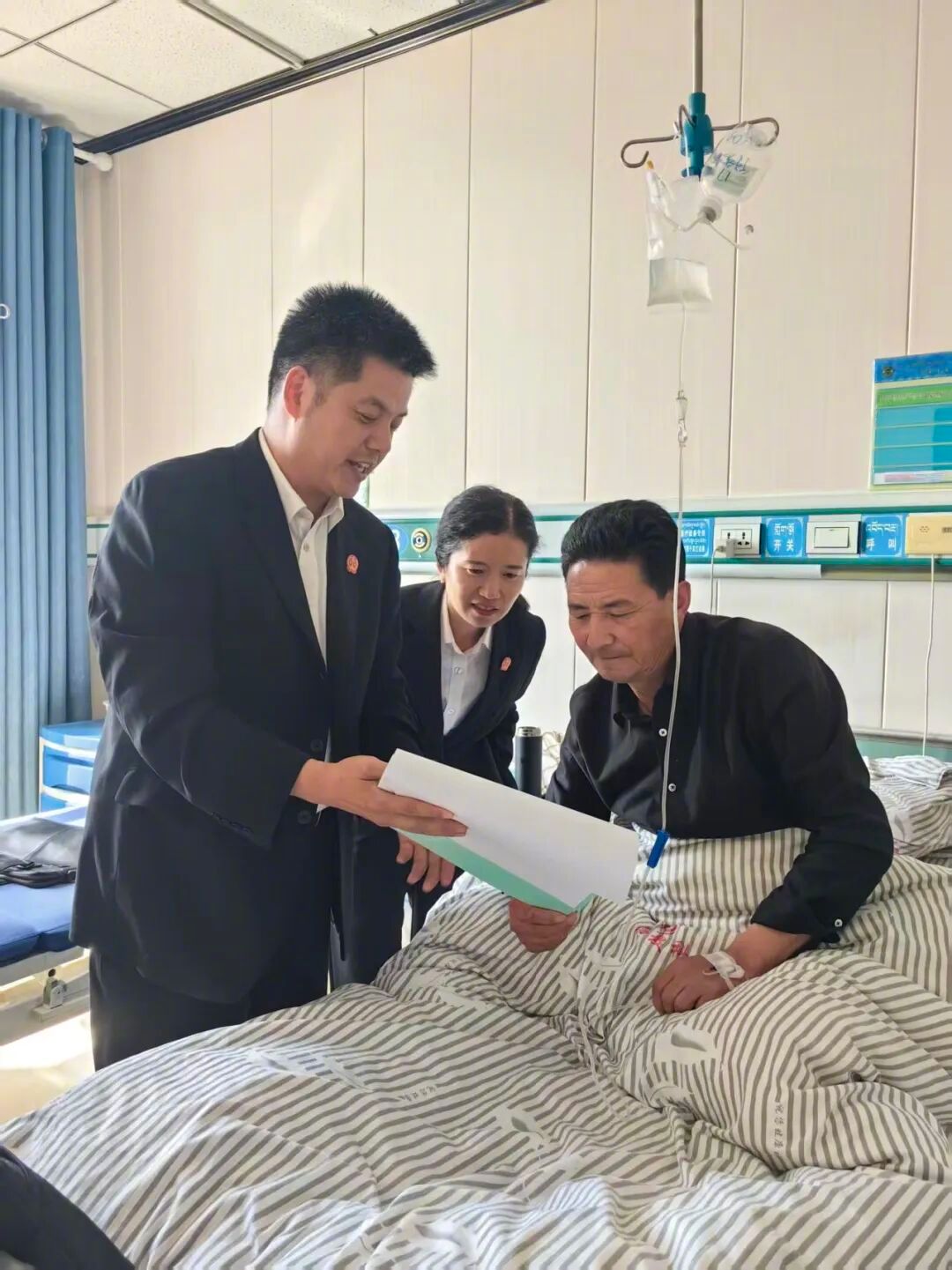 周万春（左）到青海海南州某医院为当事人调解。资料图片