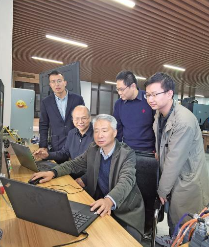 梅雪松教授（中）带领团队的教师和学生在实验室调试设备（资料照片）。 受访单位供图