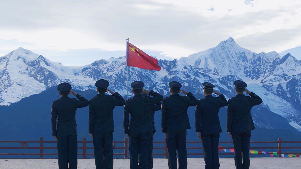 洛桑紮西與戰友們在雪山腳下面向國旗敬禮
