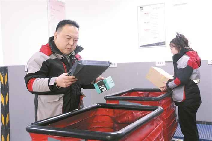 1月19日，在六师五家渠市人民路顺丰营业点，快递员岳磊（左）在分拣快件。 兵团日报常驻记者 任斐斐 通讯员 朱小丽 摄