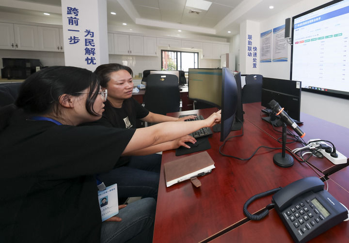 2025年5月12日，在上海市楊浦區殷行街道第五綜合網格工作站，工作人員討論通過「一鍵呼叫」與居民溝通。新華社記者 王翔 攝