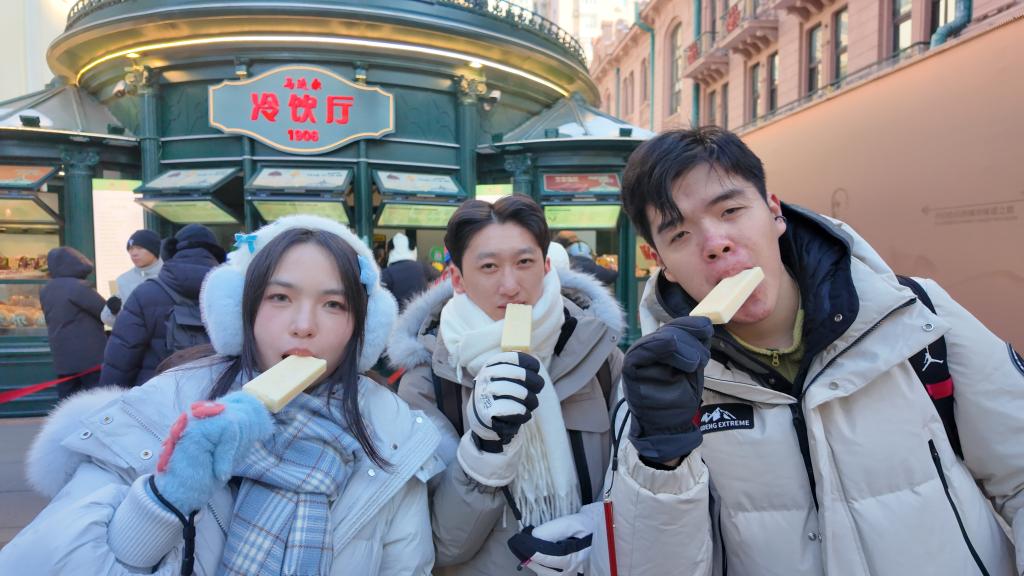 游客体验在冬天吃马迭尔冰棍儿。新华社记者 何山 摄