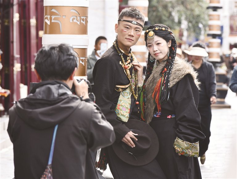 游客穿着藏装在八廓街拍摄写真。西藏日报记者 旦增兰泽 摄