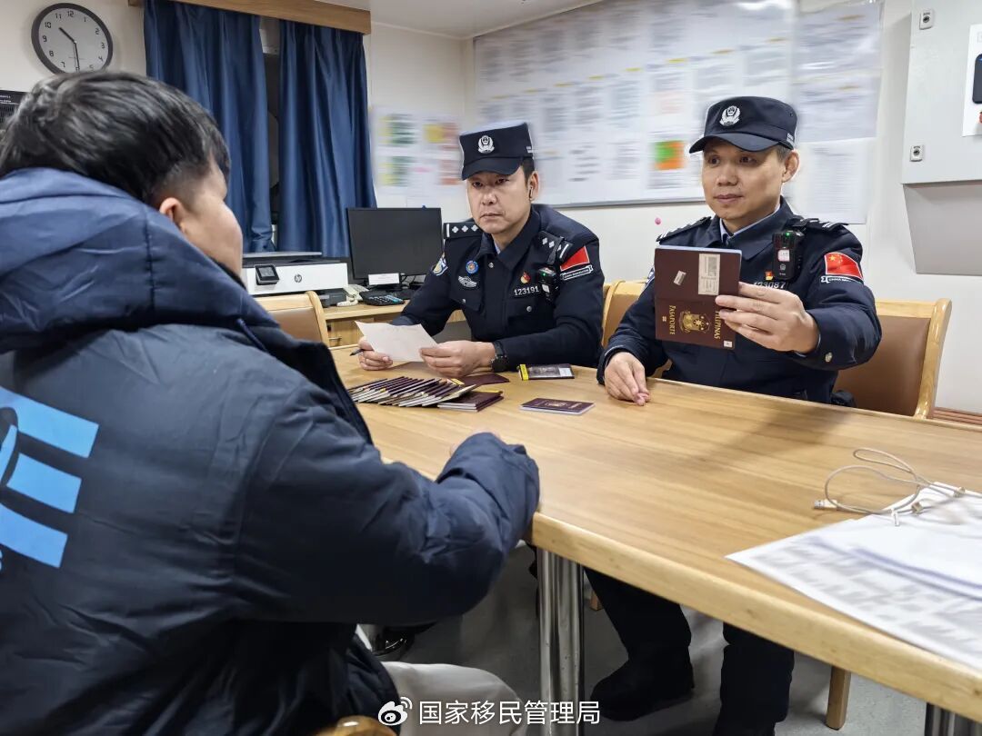 移民管理警察查验工作人员相关证件。（王伟 摄）