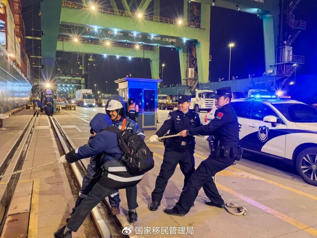 移民管理警察协助船员搭舷梯。（王伟 摄)