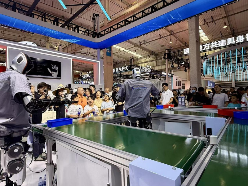 展会上正在工作的机器人被参展者围观。新京报贝壳财经记者 程子姣 摄