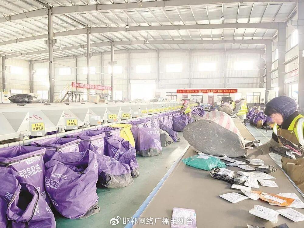 大名县快递物流配送中心内，工人在自动化快递分拣线旁工作。王翔 摄