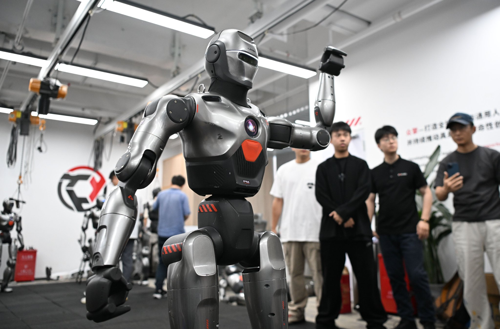 2025年6月25日，在深圳市众擎机器人科技有限公司，人形机器人挥舞手臂致意。新华社记者 邓华 摄