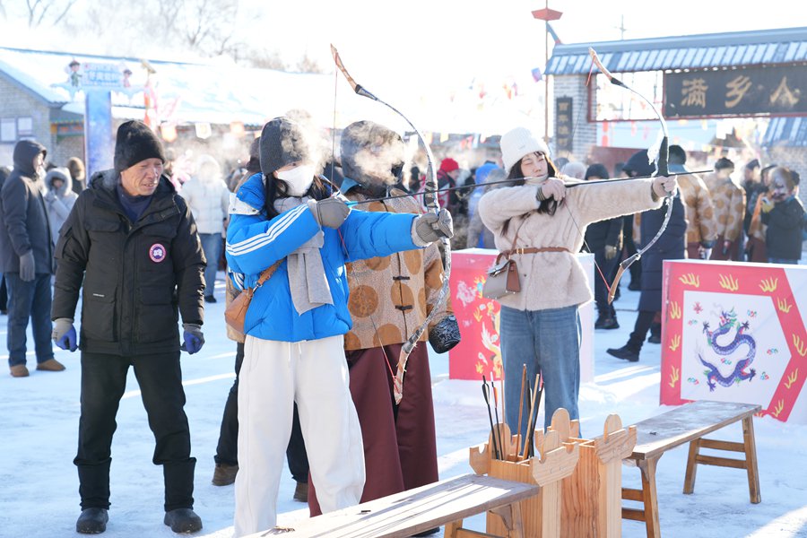 游客在黑河小乌斯力村体验满族民俗。新华社发（樊思雨 摄）
