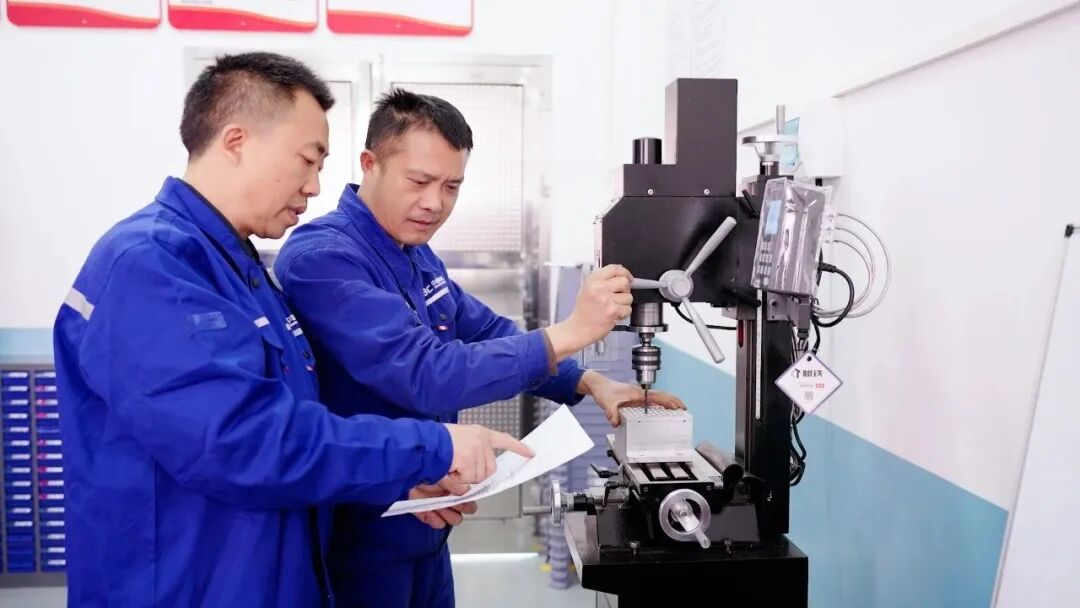 全国劳动模范李进平（左）指导青年技术人员