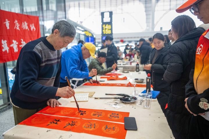 　　2月2日，在重庆东站候车大厅，志愿者为候车旅客写春联。新华社记者 唐奕 摄