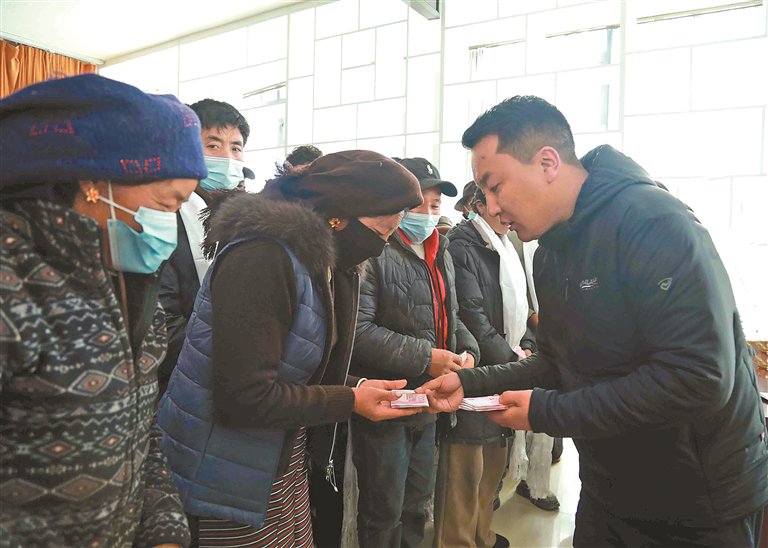图为工作人员为群众发放慰问金。记者　格桑伦珠　刘琳琳　摄