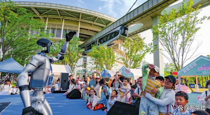 在武汉光谷空轨高新大道站,人形机器人与游客互动(2025 年 5 月 1 日摄)魏铼摄