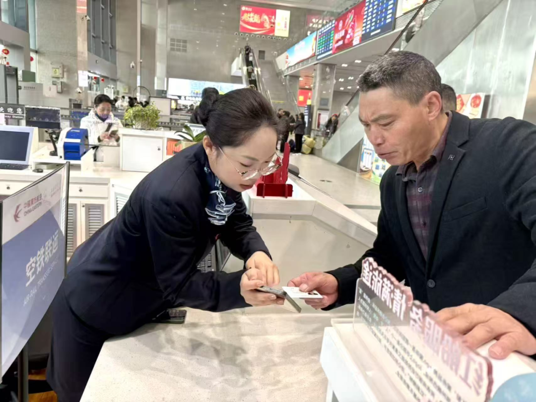 东航嘉兴南站空铁联运换乘服务中心工作人员为春运旅客指引操作