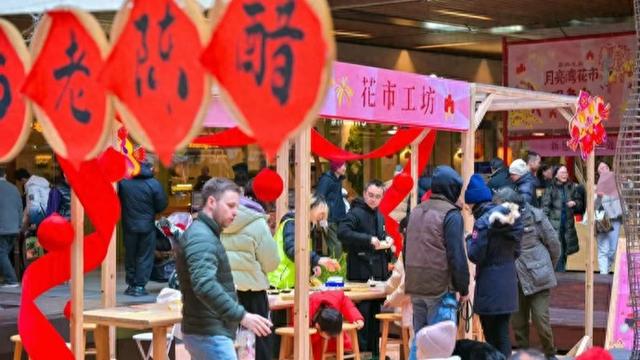 图为近日举办的蔚冉生长月亮湾花市新春集