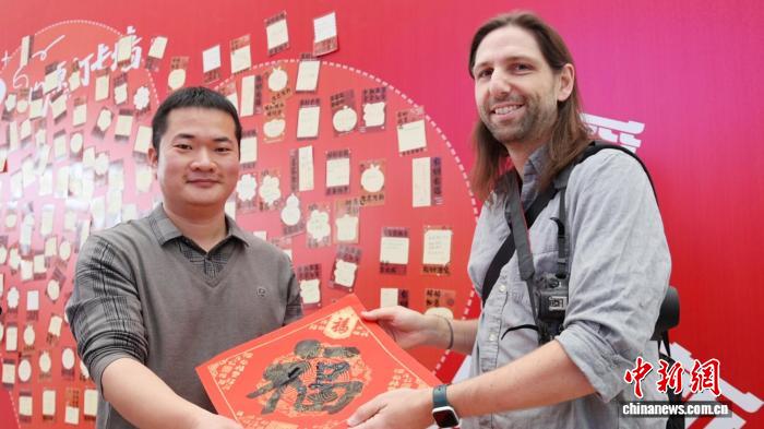 外國旅客獲贈「福」字書法作品。卓悅 攝