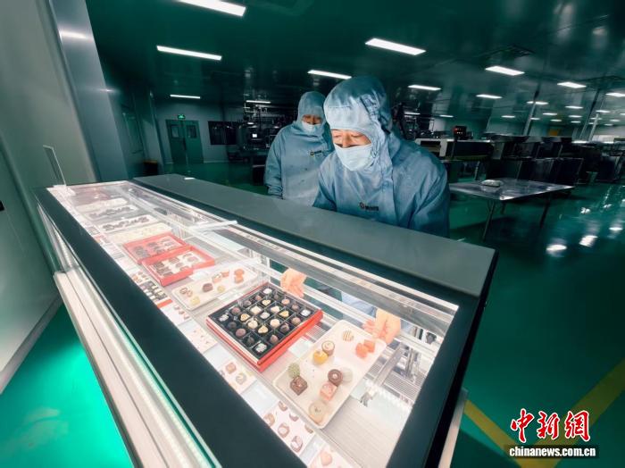 1月23日，天津市濱海新區太平鎮的一家巧克力生產企業車間，工作人員將製作好的巧克力放在展示櫃中。中新社記者 佟鬱 攝