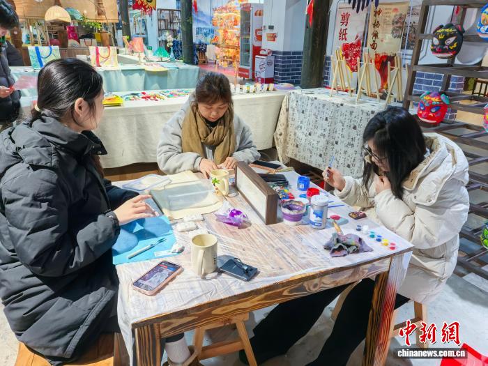 2月7日，民眾在位於湖南長沙的非遺體驗館內為儺面上色。張雪盈 攝