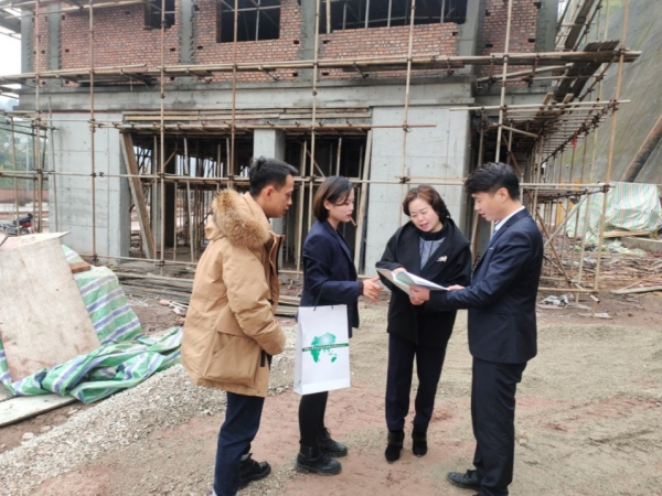 图：工作人员走村入户普及金融保险知识