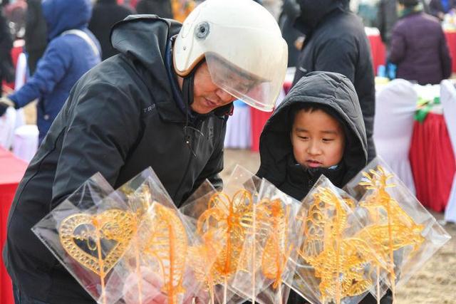 1月30日，小朋友在山东泰安大集上挑选糖画。新华社记者 朱峥 摄